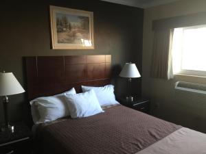 雷东多海滩海滨汽车旅馆的卧室配有带白色枕头的床和窗户。