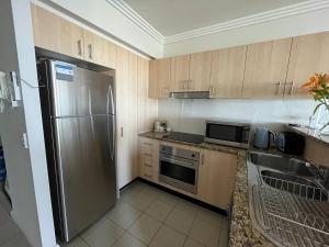 黄金海岸Ocean View Apartment at the heart of Gold Coast的厨房配有不锈钢冰箱和水槽