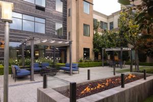 卡尔斯巴德Staybridge Suites Carlsbad/San Diego, an IHG Hotel的一座配有桌椅的建筑前的庭院