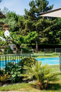 瓦朗斯克莱斯·西拉贝斯特韦斯特优质酒店的一个带围栏和一些植物的游泳池