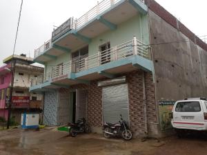 Sītāpur MūāfiHotel Parvati Residency的两辆摩托车停在楼前的建筑物