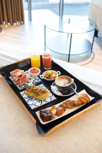 拉科鲁尼亚广场酒店的托盘,包括早餐食品和桌上的饮料