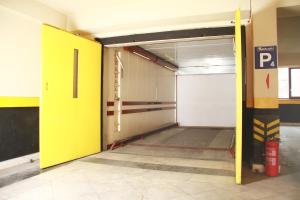 伊兹密尔奥扎克吉奥鲁公园精品酒店的一个空的停车场,有黄色的门