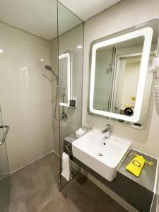 万隆YELLO Hotel Paskal Bandung的一间带水槽、淋浴和镜子的浴室