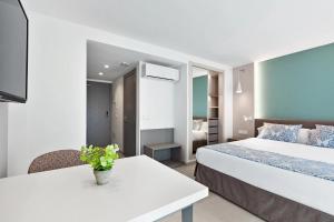 马略卡岛帕尔马Feelathome Tortuga de Mar的酒店客房设有两张床和一张桌子。
