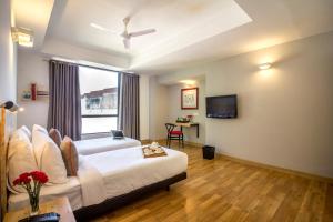 新德里Townhouse 013 New Friends Colony的一间酒店客房,配有一张床和一台电视
