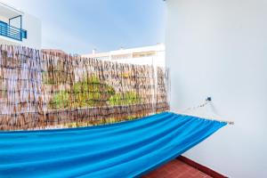 奥埃拉斯Santo Amaro Beach Family Stays的带围栏的客房内的蓝色吊床