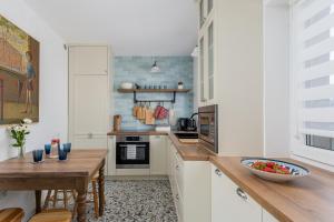 克拉科夫Luxury apartment in a truly PERFECT location的厨房配有白色橱柜和木桌