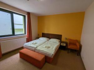 塞内奇贾尼大都会酒店的卧室配有床、椅子和窗户。