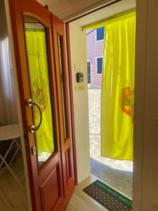 布拉诺岛Casa Bella的一间房间的一扇开门,上面有黄色窗帘