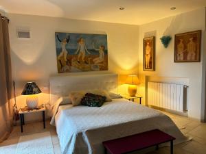阿比亚多利Monti Mannu Art的卧室配有一张床,墙上挂有绘画作品
