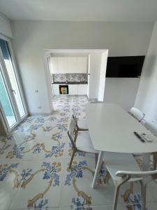 托里德欧索Torre dell’Orso Home的客房设有桌椅和瓷砖地板。