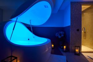 布罗德韦多米之家酒店 的一间带浴缸的浴室,享有蓝色的灯光