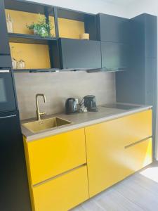 栋堡Zomeren Domburg的厨房配有黄色橱柜和水槽