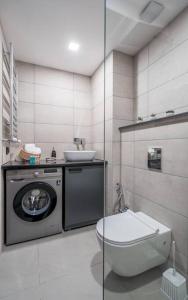 古多里Spacious 2-bed. Perfect for family & friends的浴室配有卫生间、盥洗盆和洗衣机。