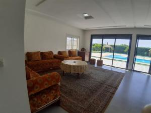盖尼特拉Magnifique villa avec piscine的带沙发和桌子的客厅以及游泳池。