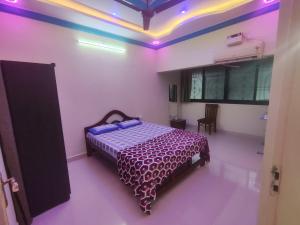 帕纳吉Serene Homestay的紫色灯室里一间卧室,配有一张床