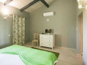 阿尔戈什Quinta dos I's - Algarve的一间卧室配有一张床,梳妆台上配有电视