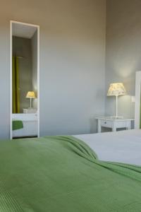 阿尔戈什Quinta dos I's - Algarve的一间卧室配有一张带绿毯的床