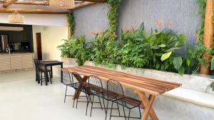 帕拉库鲁Villa Parazinho的庭院设有木桌、椅子和植物