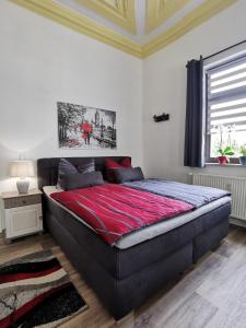 巴德塞尔佐根Ferienwohnung La Finesse的一间卧室配有一张带红色毯子的大床