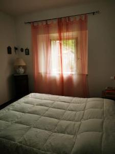 Capanne di SillanoCasa immersa nella natura的一间卧室设有一张大床和一个窗户。