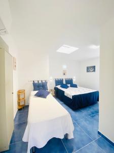 阿纳卡普里Casa Leo的蓝色瓷砖客房内的两张床