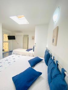 阿纳卡普里Casa Leo的一间大卧室,配有两张带蓝色枕头的床