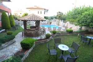 阿菲托斯Hotel Zeus的一个带桌椅的后院和一个游泳池