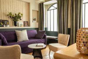 巴黎香榭丽舍雷格西亚酒店的客厅配有紫色沙发和椅子