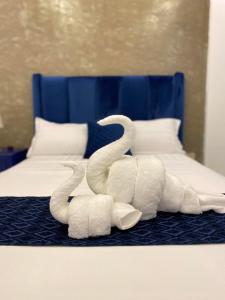 卡迪克兰Lighthouse View Boutique Hotel的床上用毛巾制成的两天鹅