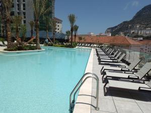 直布罗陀BRAND NEW - Studio Apartments in EuroCity - Large Pool - Rock View - Balcony - Free Parking - Holiday and Short Let Apartments in Gibraltar的一个带躺椅的游泳池