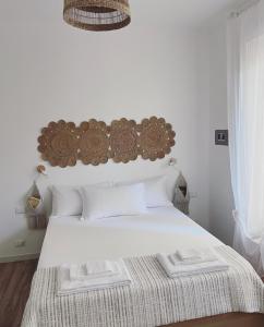 福洛尼卡Casa Amapola的卧室配有白色的床和木制床头板