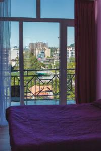 高尼奥Two Bedroom Apartment With Balcony In Gonio Beach的一间卧室设有紫色的床和大窗户