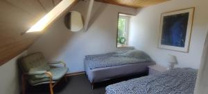 EngesvangBøllingsø Camping的卧室配有床、椅子和窗户。