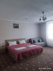 卡缅涅茨-波多利斯基Apart-hotel 24/7的一间卧室配有一张大床和一张沙发