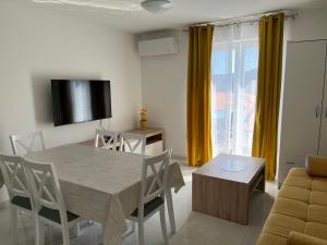 拉巴克Apartments Zahtila - Berto的客厅配有桌椅和电视。