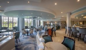 百利科内尔斯利福罗赛尔酒店的一间带桌椅的餐厅和一间酒吧