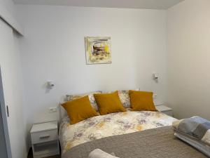 拉巴克Apartments Zahtila - Berto的一间卧室配有一张带黄色枕头的床