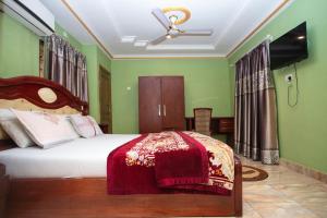 库马西Glory Hills Hotel的一间卧室配有一张带红色毯子的床
