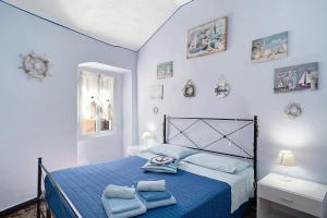 因佩里亚Casa Acqua Mare Parasio的一间卧室配有蓝色的床和毛巾