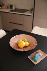 贾迪尼-纳克索斯DOLCEVITA NAXOS terrace&apartment的桌子上放着一盘柠檬,还有一本书