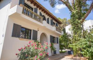 马略卡岛帕尔马Villa Margarita的白色的房子,有黑色百叶窗和粉红色的鲜花