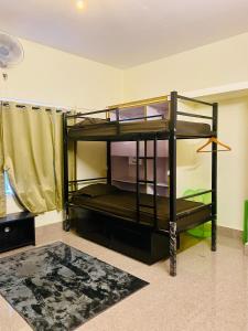 迈索尔Crossroads Hostel 1980的配有2张双层床的宿舍间设有地毯。