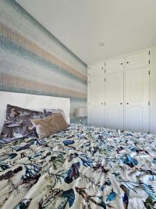 阿玛考德佩拉Varandas de Luz的一间卧室配有一张带彩色毯子的床