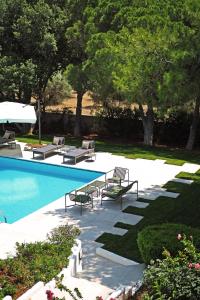 拉格尼西Villa Oasis with Large Pool Athenian Riviera Lagonissi的一个带躺椅和桌子的游泳池