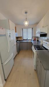 拉瓦尔Vacation House central location from anywhere in Montreal的厨房配有白色家电和白色冰箱