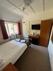 布拉克内尔阿德默勒旅馆的一间卧室配有一张床和一张书桌及电视