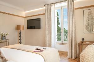 科涅克La Nauve, Hôtel & Jardin - Relais & Châteaux的一间卧室设有一张床和一个大窗户