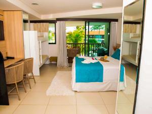 嘎林海斯港Porto Beach Resort - Marulhos的一间设有床铺、厨房和桌子的房间